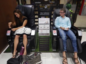 Ashley and Eli enjoying the massage chairs at the airport