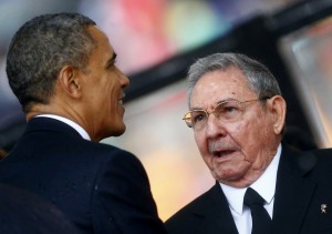 U.S. President Barack Obama (L) greets Cuban President Raul Castro before giving his speech at the memorial service for late South African President Nelson Mandela at the First National Bank soccer stadium, also known as Soccer City, in Johannesburg December 10, 2013. Obama shook the hand of Castro at a memorial for Nelson Mandela on Tuesday, a rare gesture between the leaders of two nations which have been at loggerheads for more than half a century. REUTERS/Kai Pfaffenbach (SOUTH AFRICA - Tags: POLITICS OBITUARY) - RTX16C61