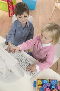 Boy Helping Girl Use Computer